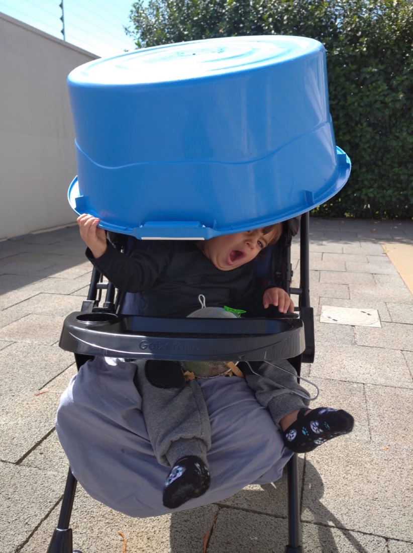 Humberto no carrinho com um balde azul na cabeça
